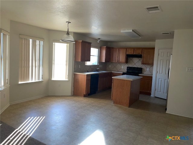 kitchen featuring a center island, black appliances, hanging light fixtures, sink, and ventilation hood