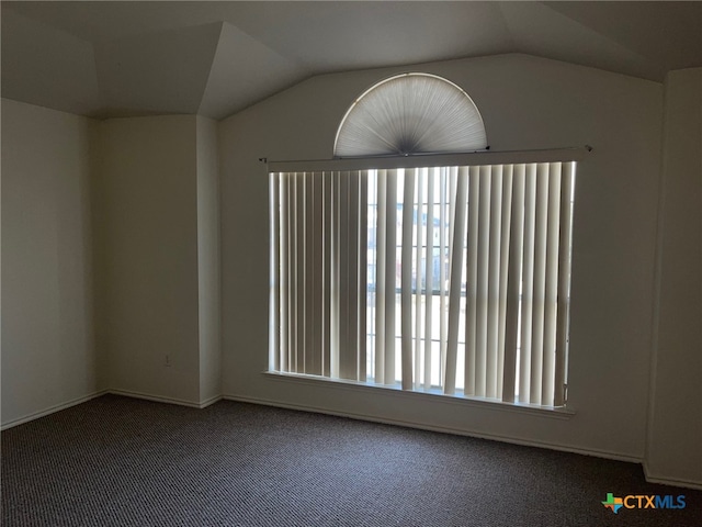 carpeted empty room featuring vaulted ceiling