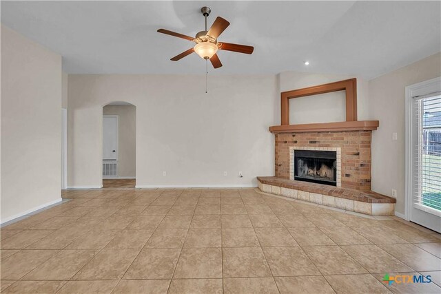 2922 Starlight Dr, Copperas Cove, TX 76522 - unfurnished living room with a ceiling fan, tile patterned floors, arched walkways, a fireplace, and lofted ceiling