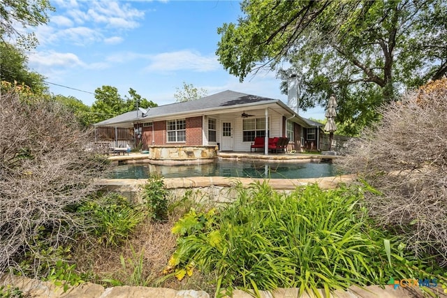 4501 Arrowhead Dr, Temple, TX 76502 - back of property featuring a ceiling fan, a chimney, an outdoor pool, and brick siding
