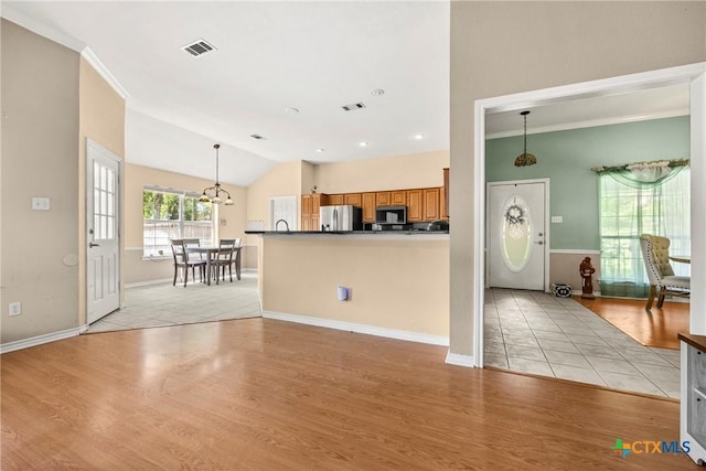 4501 Arrowhead Dr, Temple, TX 76502 - kitchen featuring stainless steel appliances, brown cabinetry, light wood-style floors, decorative light fixtures, and ornamental molding