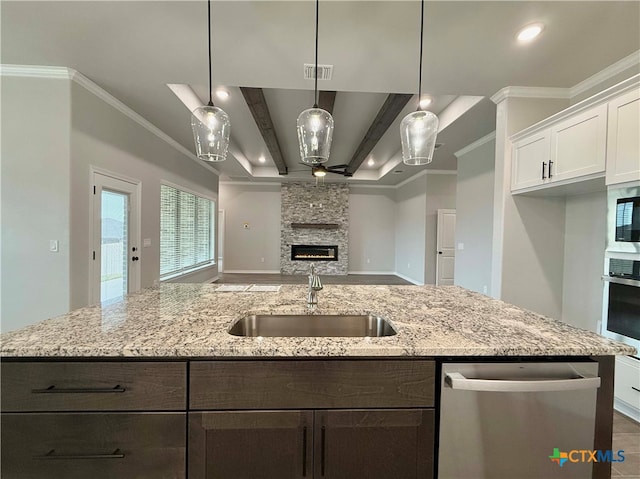 kitchen with a fireplace, stainless steel appliances, crown molding, beamed ceiling, and white cabinetry