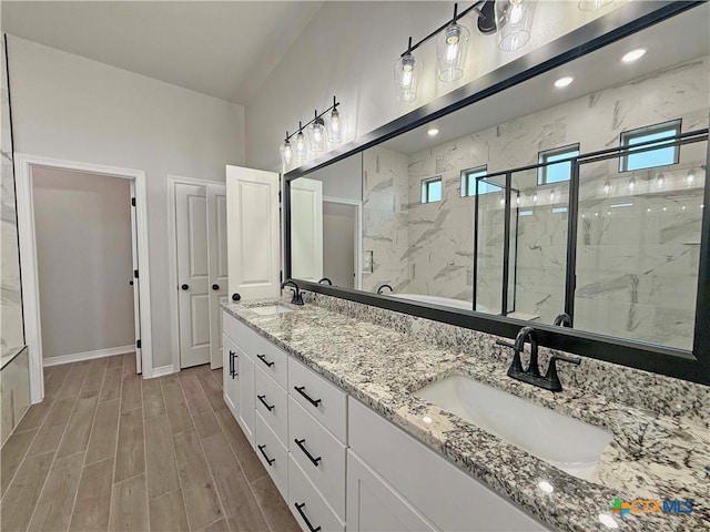2021 Yarrow Rd, Temple, TX 76502 - bathroom featuring a marble finish shower, double vanity, and wood finished floors