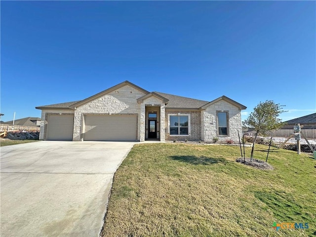 2021 Yarrow Rd, Temple, TX 76502 - view of front of house with a garage, driveway, stone siding, and a front lawn