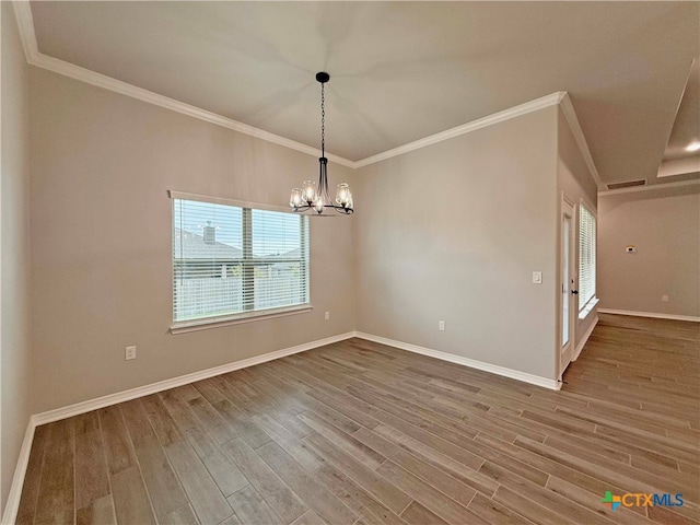 unfurnished dining area featuring ornamental molding, hardwood / wood-style flooring, and a notable chandelier