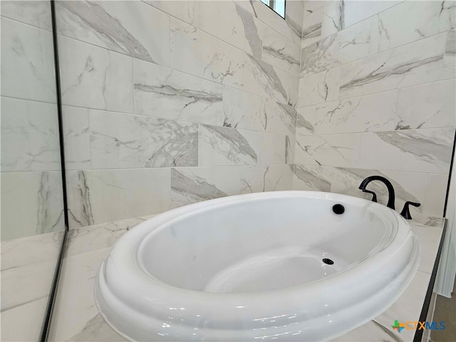 bathroom with a washtub and tile walls