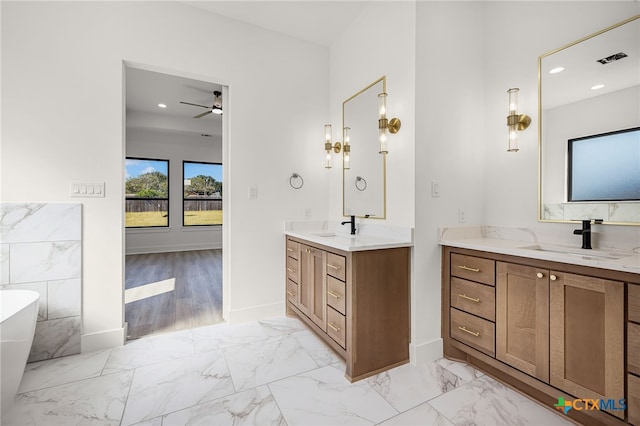 bathroom with a washtub, vanity, wood-type flooring, and ceiling fan