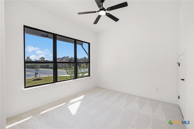 spare room with light colored carpet and ceiling fan