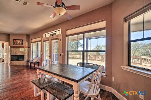 dining space with a fireplace, french doors, ceiling fan, and dark hardwood / wood-style floors