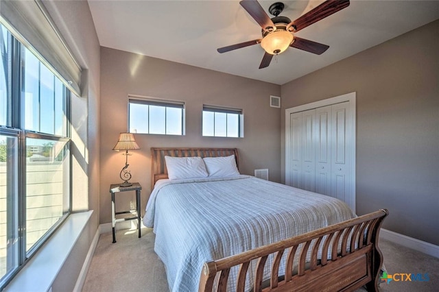 carpeted bedroom with ceiling fan and a closet