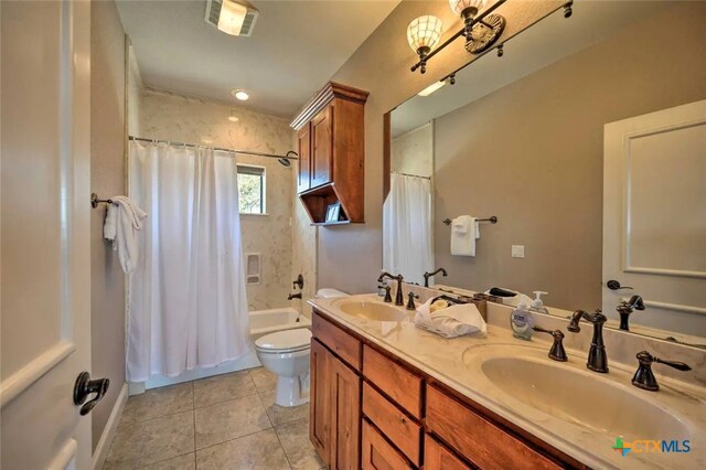 full bathroom with toilet, tile patterned flooring, vanity, and shower / bath combo with shower curtain