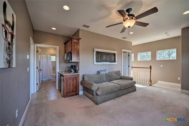 living room with ceiling fan and light colored carpet