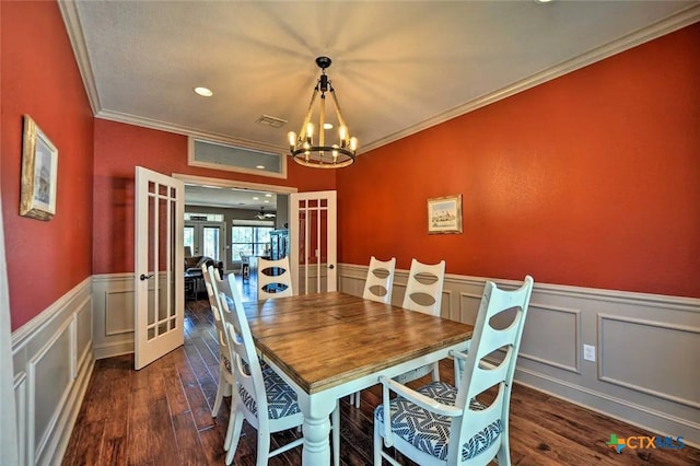 dining area with ornamental molding, dark wood-type flooring, french doors, and an inviting chandelier