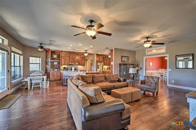 living room with a textured ceiling and dark wood-type flooring