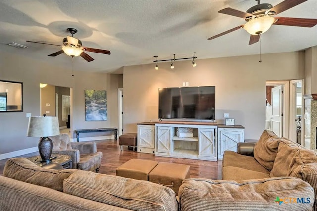 living room with rail lighting, a textured ceiling, and hardwood / wood-style flooring