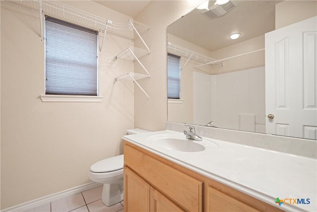 bathroom with tile patterned flooring, vanity, a shower, and toilet