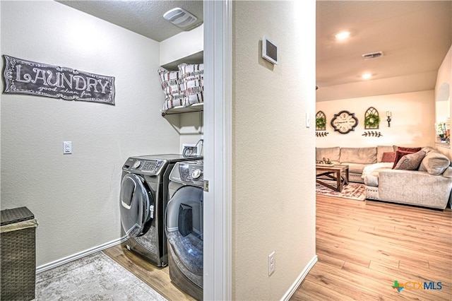 9300 Vaquero Way, Killeen, TX 76542 - washroom featuring separate washer and dryer, wood finished floors, a textured wall, and baseboards