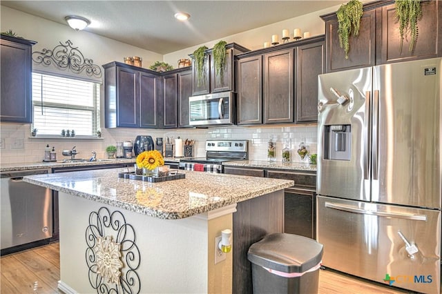 9300 Vaquero Way, Killeen, TX 76542 - kitchen with appliances with stainless steel finishes, dark brown cabinetry, tasteful backsplash, and a center island