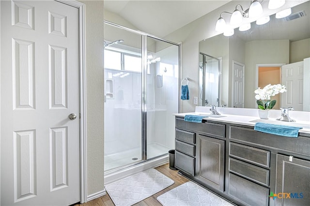 9300 Vaquero Way, Killeen, TX 76542 - bathroom with a shower stall, double vanity, wood finished floors, and lofted ceiling
