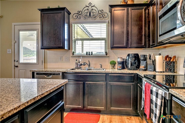 9300 Vaquero Way, Killeen, TX 76542 - kitchen with appliances with stainless steel finishes, a sink, tasteful backsplash, dark brown cabinets, and light wood finished floors