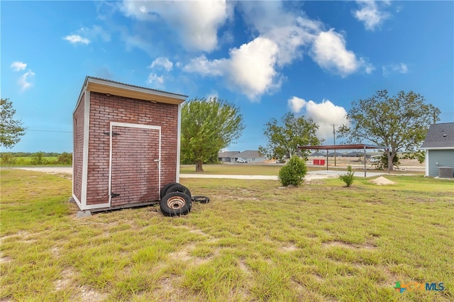 view of yard featuring an outbuilding, a carport, and cooling unit