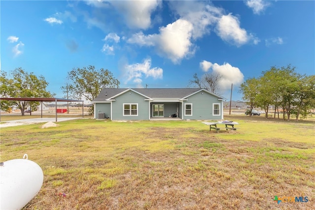 rear view of property with a lawn and a carport