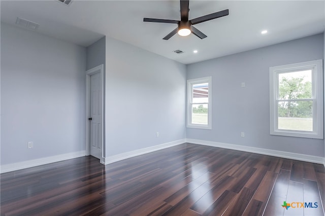 spare room with ceiling fan, dark hardwood / wood-style floors, and a healthy amount of sunlight