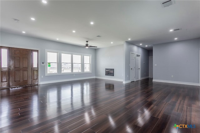 unfurnished living room featuring dark hardwood / wood-style flooring and ceiling fan