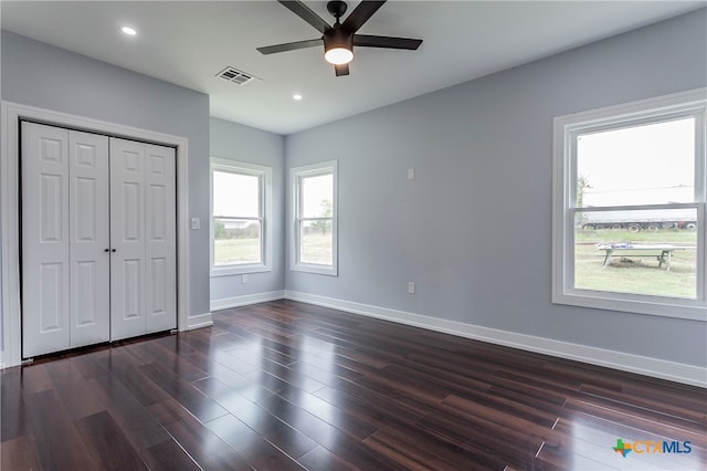 unfurnished bedroom with dark hardwood / wood-style flooring, a closet, and ceiling fan