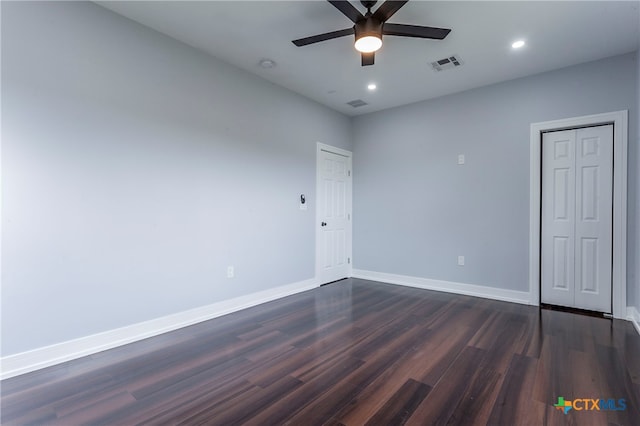 spare room with dark wood-type flooring and ceiling fan