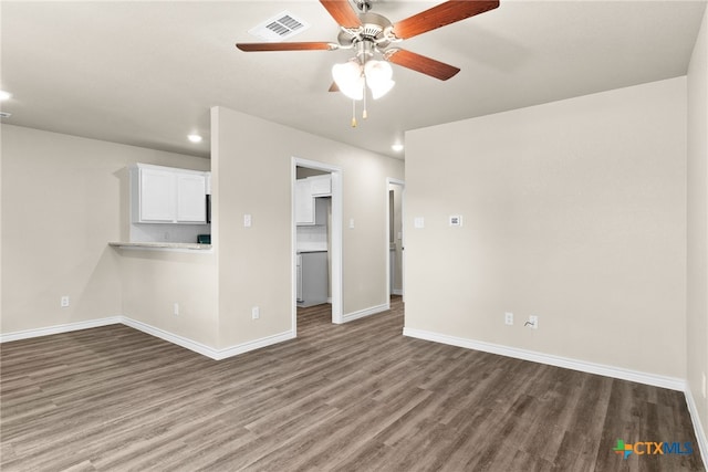 unfurnished living room featuring dark wood-type flooring and ceiling fan