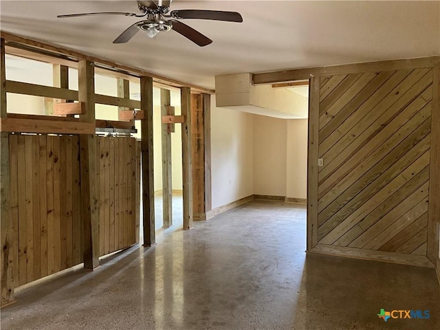 364 N Blackburn Ave, Port Lavaca, TX 77979 - empty room featuring wooden walls, ceiling fan, concrete floors, and baseboards