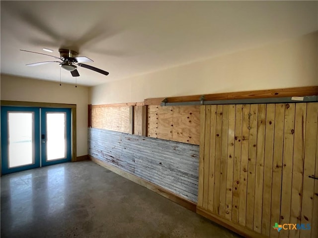 364 N Blackburn Ave, Port Lavaca, TX 77979 - empty room featuring french doors, a ceiling fan, finished concrete flooring, baseboards, and wooden walls
