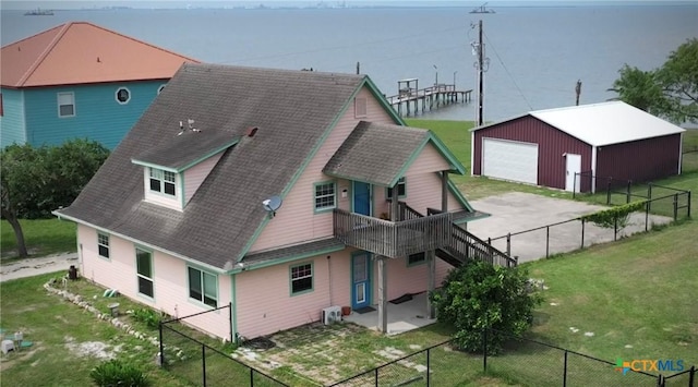 364 N Blackburn Ave, Port Lavaca, TX 77979 - back of property featuring a garage, roof with shingles, an outbuilding, and concrete driveway
