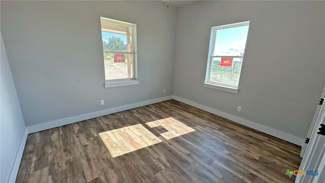 spare room with dark hardwood / wood-style flooring and ceiling fan