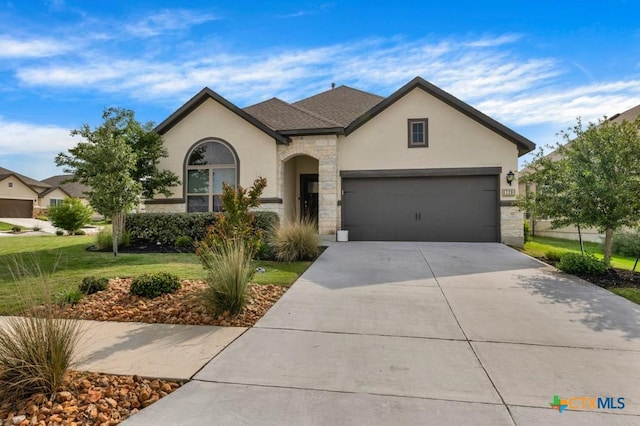 129 La Cima, Boerne, TX 78006 - view of front facade featuring stucco siding, a front yard, driveway, an attached garage, and stone siding