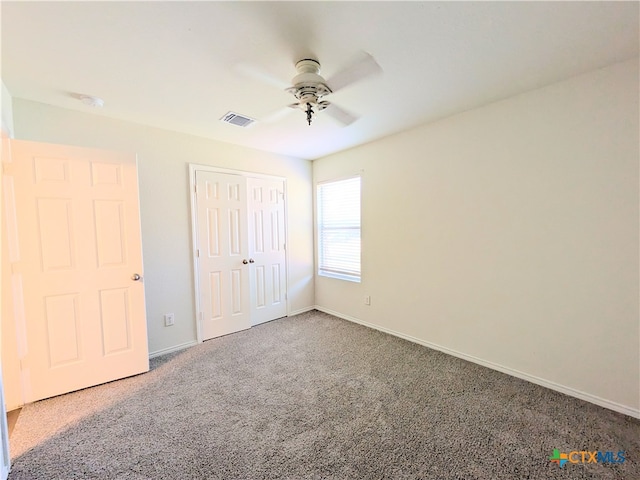 unfurnished bedroom featuring carpet flooring, ceiling fan, and a closet