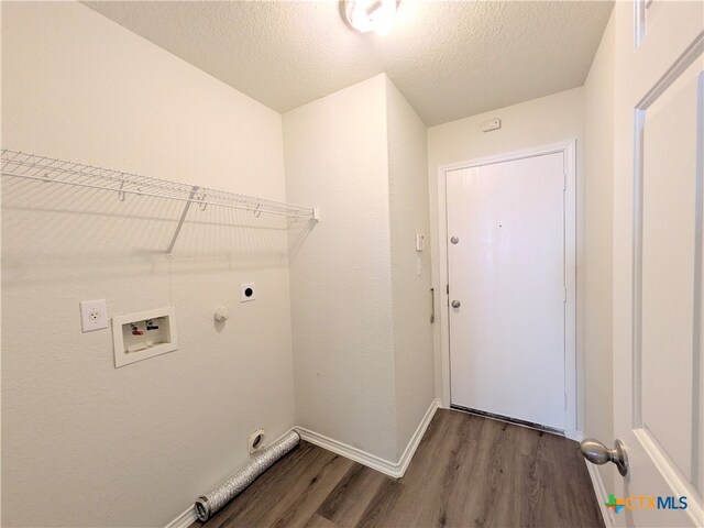 laundry room with electric dryer hookup, gas dryer hookup, hookup for a washing machine, a textured ceiling, and dark hardwood / wood-style flooring