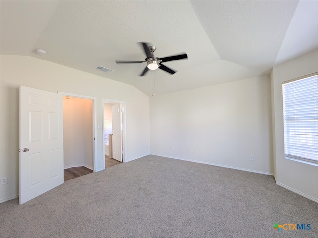 carpeted empty room featuring ceiling fan, lofted ceiling, and a textured ceiling