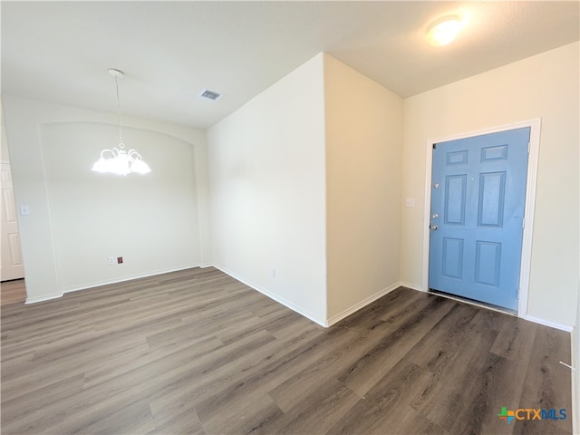 interior space with dark wood-type flooring and a notable chandelier