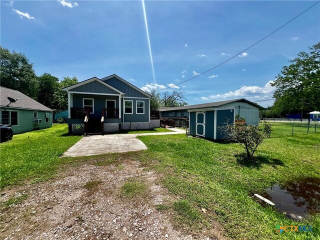 313 Rorem Ave, Palacios, TX 77465 - back of house featuring a patio, a storage unit, a deck, an outbuilding, and a yard