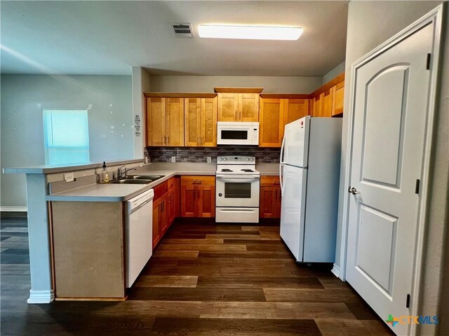 313 Rorem Ave, Palacios, TX 77465 - kitchen with decorative backsplash, a sink, visible vents, dark wood-type flooring, and white appliances