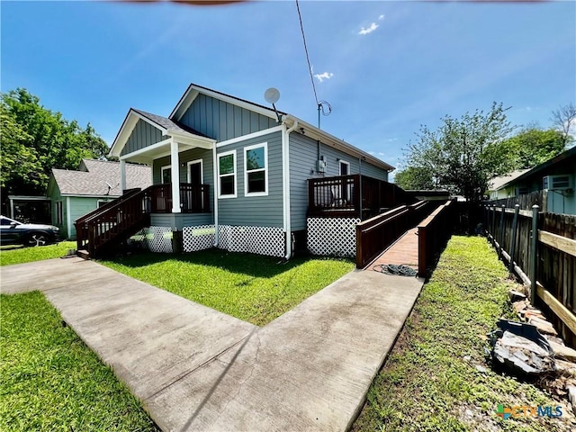 313 Rorem Ave, Palacios, TX 77465 - bungalow with a porch, a front yard, board and batten siding, and fence