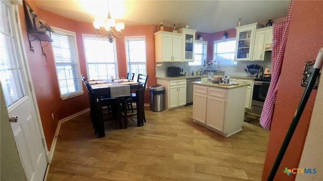 kitchen featuring white cabinets, stainless steel appliances, a chandelier, a center island, and hanging light fixtures