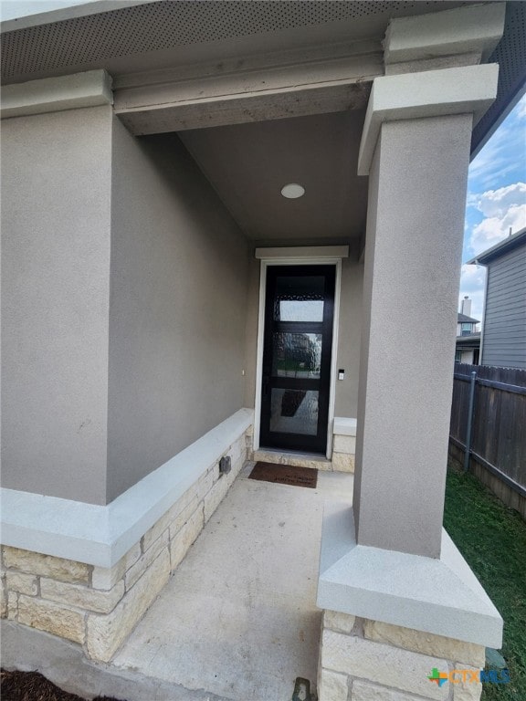 1306 Daniel Dr, Belton, TX 76513 - view of exterior entry featuring fence, stucco siding, and stone siding