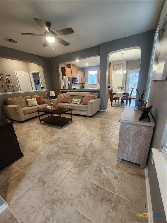 1306 Daniel Dr, Belton, TX 76513 - living area featuring arched walkways, a ceiling fan, and a chandelier