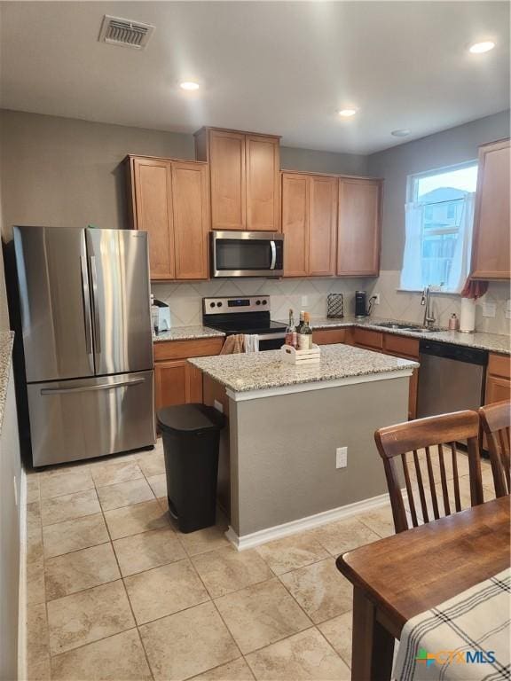 1306 Daniel Dr, Belton, TX 76513 - kitchen with stainless steel appliances, a sink, a kitchen island, backsplash, and recessed lighting