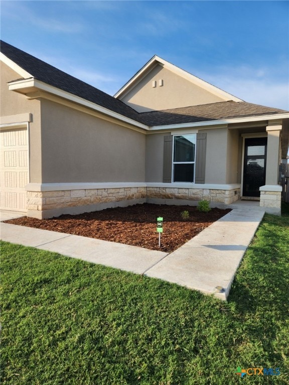 1306 Daniel Dr, Belton, TX 76513 - view of front of property featuring stone siding, stucco siding, an attached garage, and a front lawn