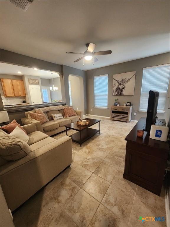 1306 Daniel Dr, Belton, TX 76513 - living room with arched walkways, ceiling fan, and light tile patterned floors
