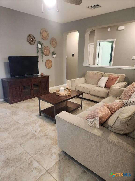 1306 Daniel Dr, Belton, TX 76513 - living area featuring arched walkways, a ceiling fan, and baseboards